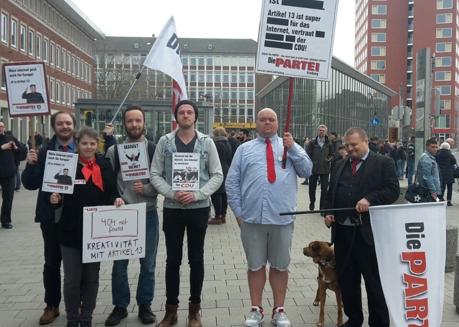 Die LISTE und die PARTEI Münster treffen sich am Hauptbahnhof mit Schildern